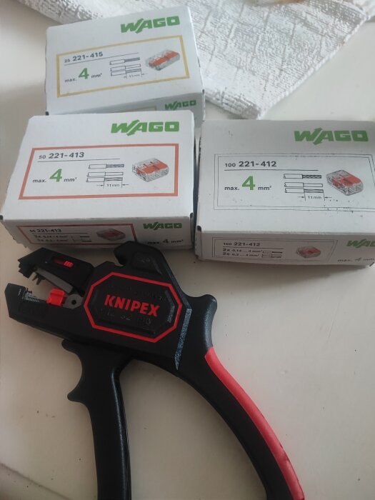 Knipex tång framför WAGO-lådor på ett bord, relaterat till byggprojekt och rabatt på Amazon.