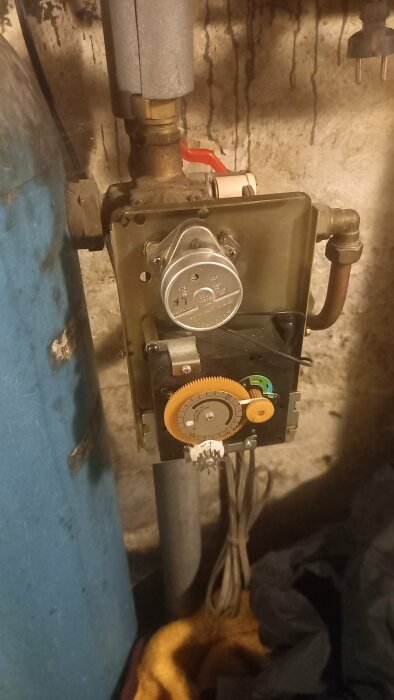 Värmesystemets styrmojäng med kugghjul och röranslutningar i ett pannrum.