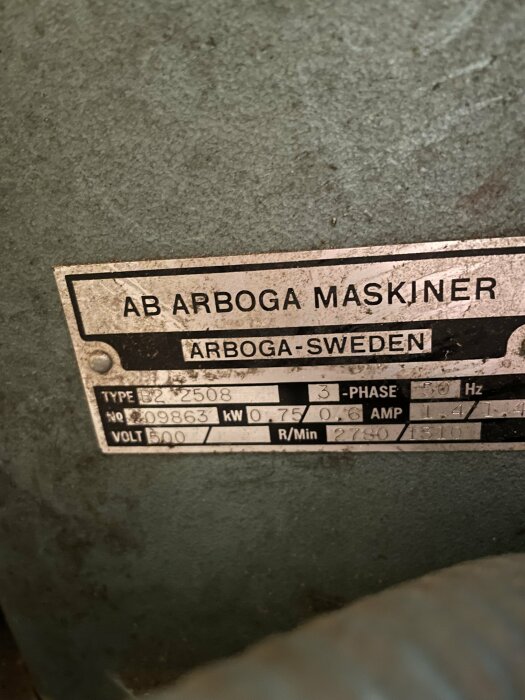 Namnskylt på en pelarborr från AB Arboga Maskiner med typ- och serienummer på en grå metalldel.