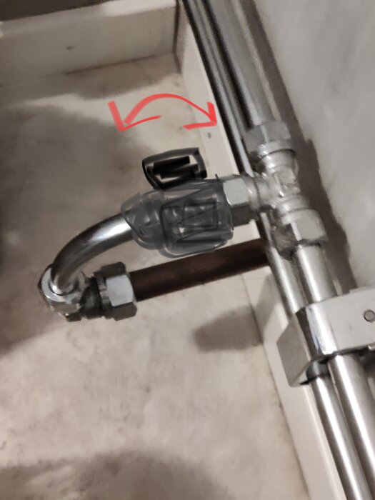 Vattenledningar och T-koppling markerad med röd pil, föreslagen plats för ballofixinstallation.