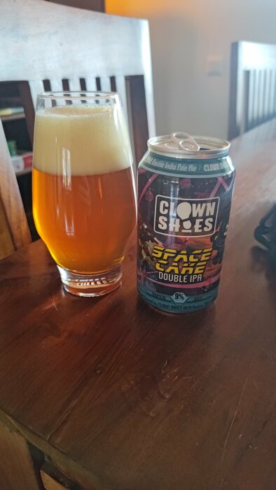 Ett glas med öl och en burk "Space Cake Double IPA" på ett träbord.