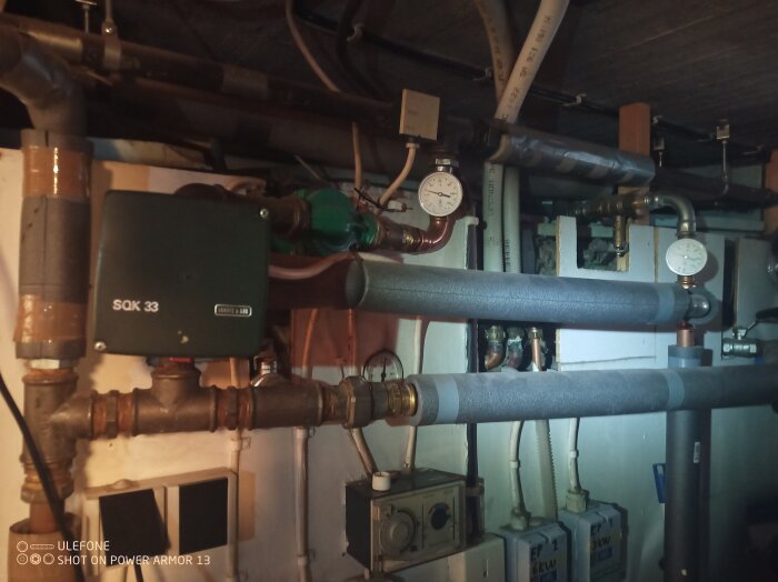 Inomhusbild av ett värmesystem med rör, ventiler och mätinstrument i ett pannrum.