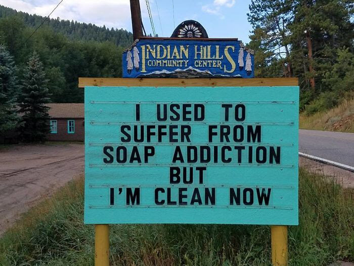 Humorskylt utanför Indian Hills Community Center med texten "I used to suffer from soap addiction but I'm clean now".