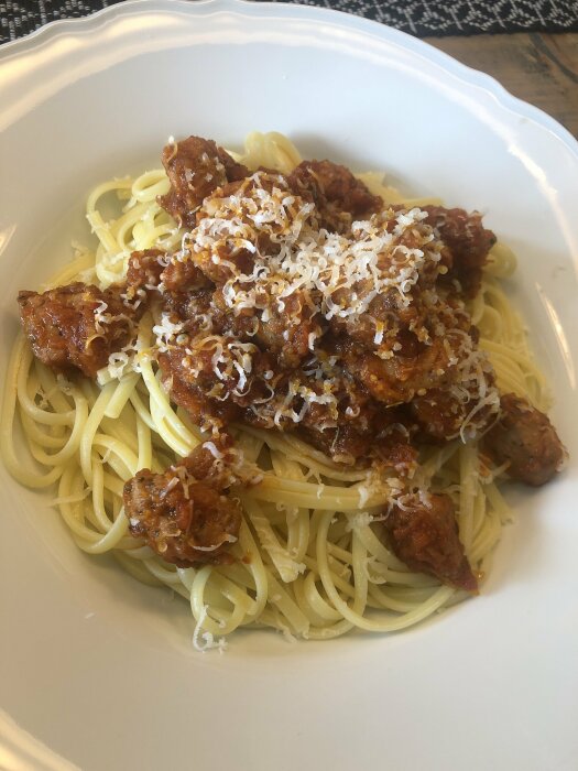 Spaghetti med basilika och tomatsås toppad med salsiccia och riven parmesan.