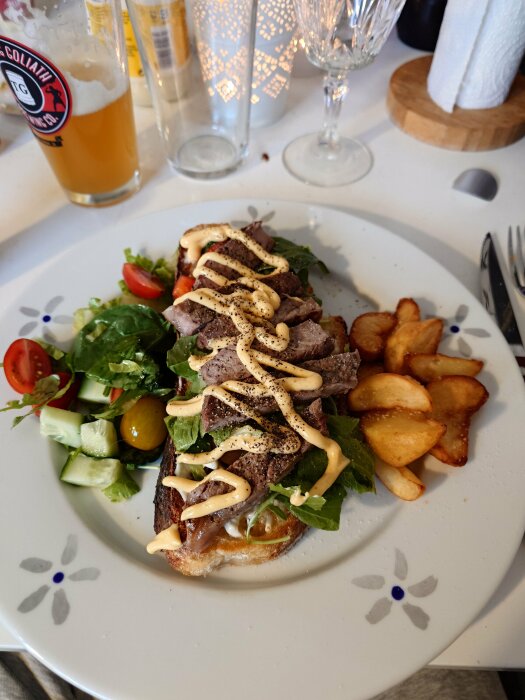 Stekt levainbröd med skivor av kött och mango/habanero-majonnäs, sallad, tomat, gurka och stekt potatis.