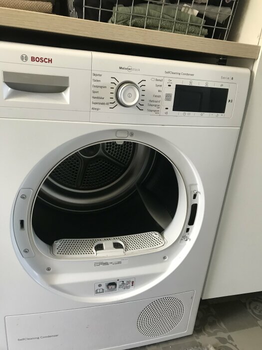 Bosch Serie 8 torktumlare med öppen lucka som visar inredning och kontrollpanel.