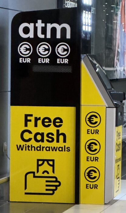 Gul och svart uttagsautomat med texten "Free Cash Withdrawals" och eurosymboler.