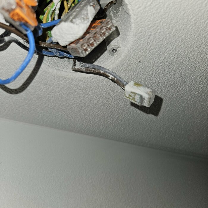 Elanslutningar och dosa i tak med synlig etikett "tak-badrum" på en kabel.