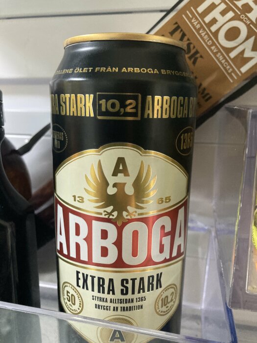 Burk av Arboga Extra Stark öl med alkoholhalt 10,2% placerad på en hylla.