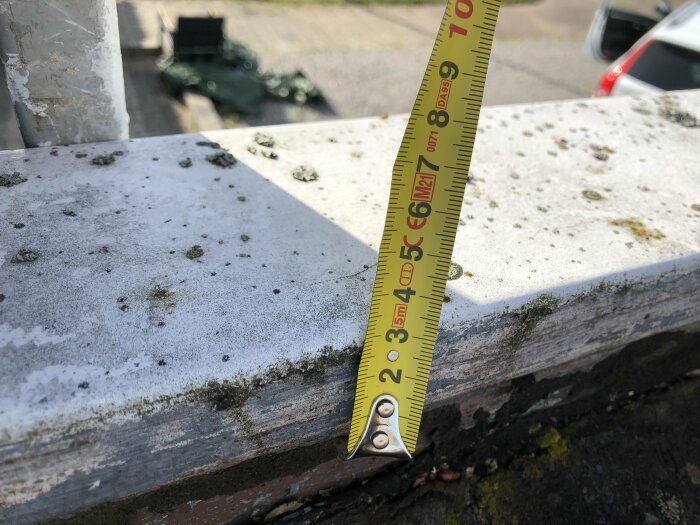 Måttband som mäter kantprofil på betongelement i utomhusmiljö.
