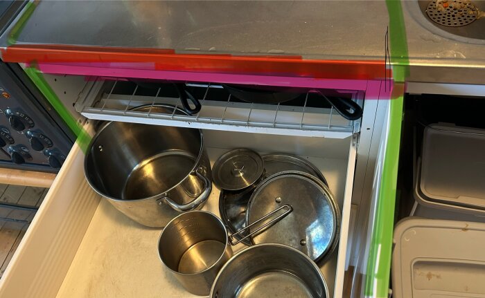 Kök med diskho, öppen diskmaskin och spis, markerade linjer visar plats för inbyggnad.