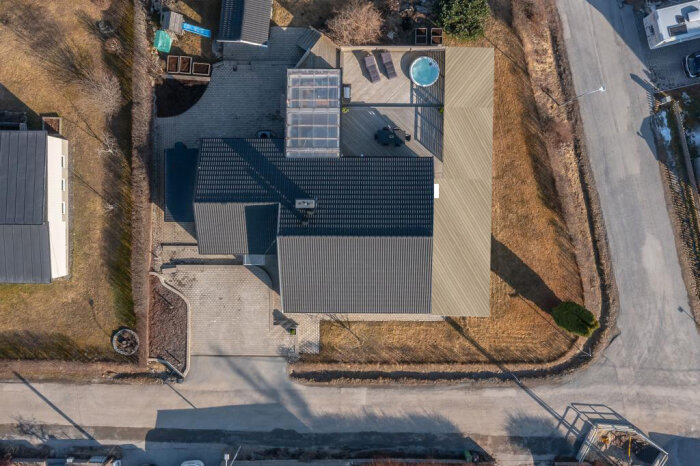 Flygbild över ett bostadshus med befintlig trall och planerad utbyggnation markerad med snören.