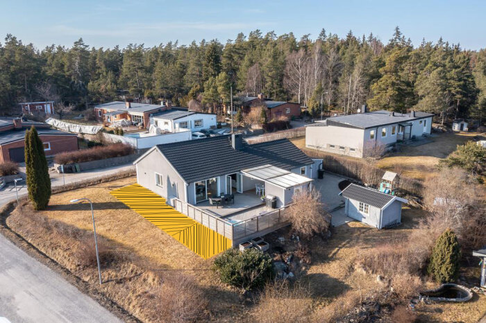 Översiktsbild av hus med planerade områden för altanutbyggnad markerade i gult mot en gräsmatta.