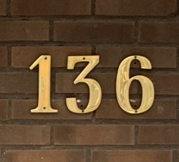Gjutna mässingssiffror "136" på tegelvägg som söker matchande "1".