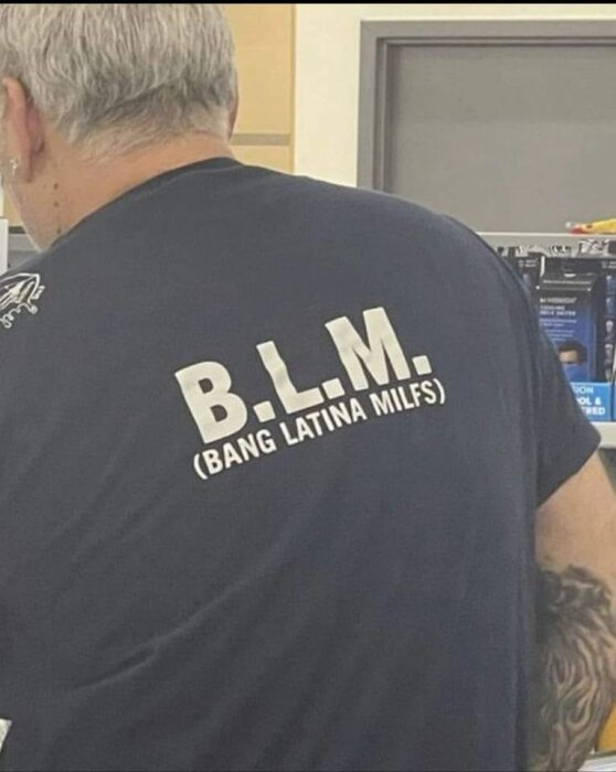 Person med en t-shirt med texten "B.L.M. (BANG LATINA MILFS)" på ryggen.