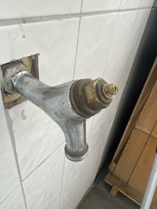 Vattenutkastare i garage utan handtag mot kaklad vägg.