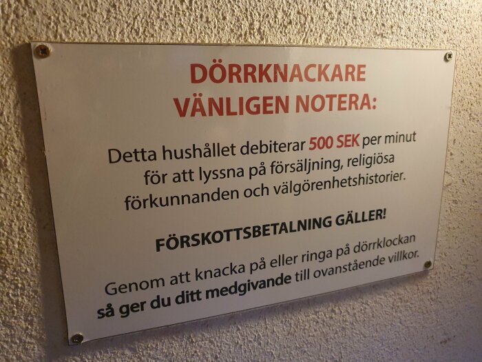 Skylt som varnar dörrknackare om debitering på 500 SEK/minut för oönskade sälj- och välgörenhetssamtal.