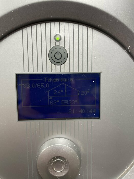 IVT värmepumps display som visar hög temperatur och varningsikoner, indikerande ett tekniskt problem.