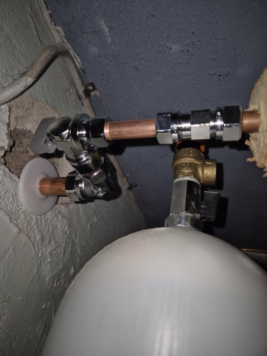 Vinkelmonterad minikulventil och förlängda rör på en varmvatteninstallation.