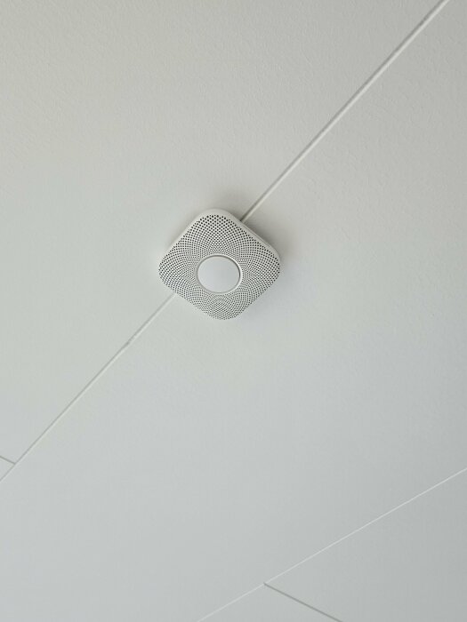 Vitt tak med en inbyggd LED-spotlight och geometriska linjer, ren minimalistisk design.