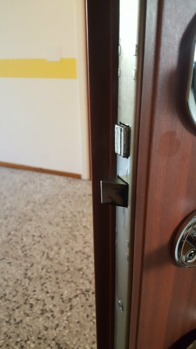 Ytterdörr med delvis utskjuten låskolv, problem med låsfunktionen beskrivs.