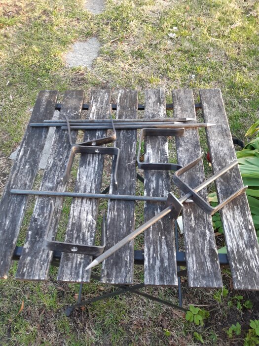 Svetsade metallfästen och plankor på en gräsmatta, avsedda som avgränsningar för en robotgräsklippare.
