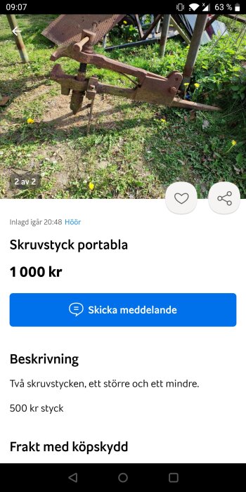 Rostig portabel skruvstycke i metall monterad på grön gräsmatta.