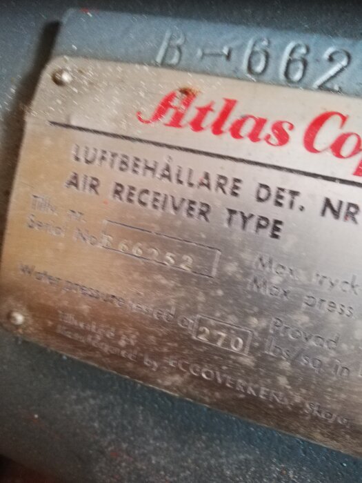 Metallskylt på maskinutrustning med texten "Atlas Copco Luftbehållare typ Air Receiver" och tekniska specifikationer.