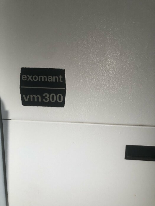 Etikett med texten "exomant vm 300" på en vit yta av en vattenberedare