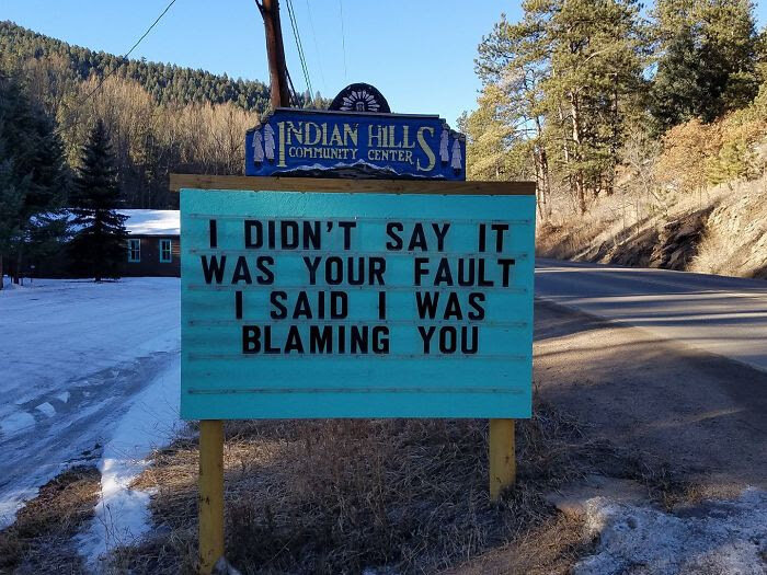 Skylt utanför Indian Hills Community Center med texten "I DIDN'T SAY IT WAS YOUR FAULT I SAID I WAS BLAMING YOU".