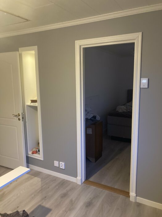 Nyinstallerad innerdörr i ett renoverat rum med ljust laminatgolv och vita lister.