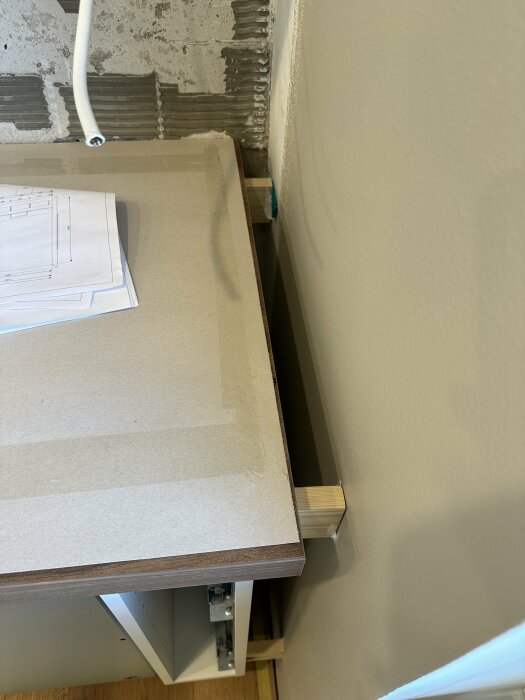 Laminatbänkskiva för kort för köksskåp med synlig vägg bakom och ritning på bänken.