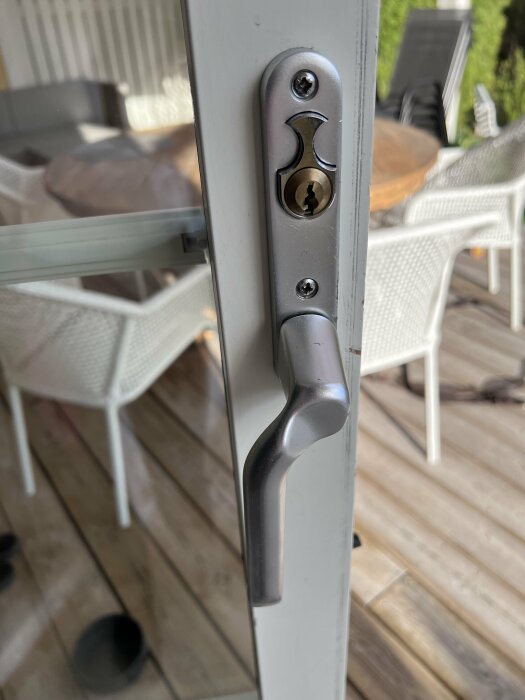 Altandörrhandle med låscylinder och nyckelhål på utsidan av en stängd dörr