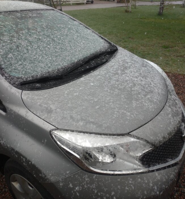 Bil täckt av snö i vad som verkar vara en vårmånad.