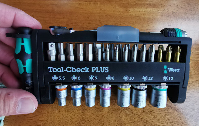 Hand håller en kompakt Wera Tool-Check PLUS verktygssats med utbytbara bits och hylsor.