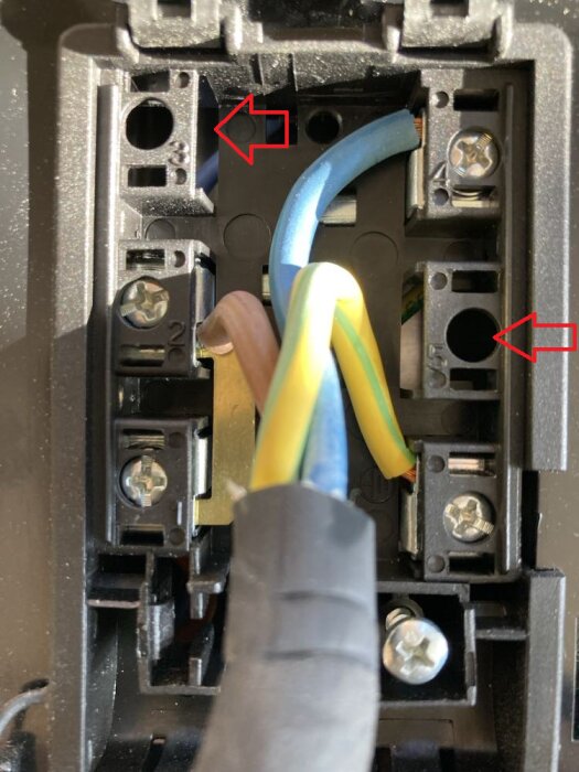 Elektrisk anslutning för induktionsspis med tre kablar och två markerade metallkopplingar.