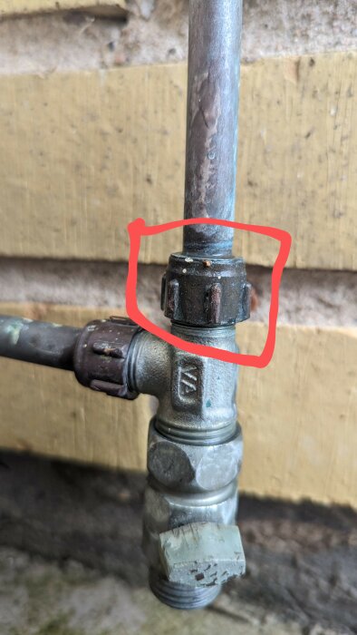 Vattenutkastare med en röd markering som pekar ut läckageplatsen på en kopplingsdel.