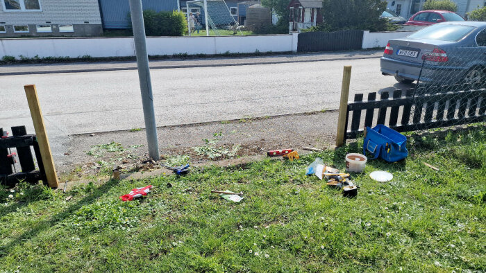 Testbygge av staketsektion med verktyg och material framför befintligt gammalt staket och hus.