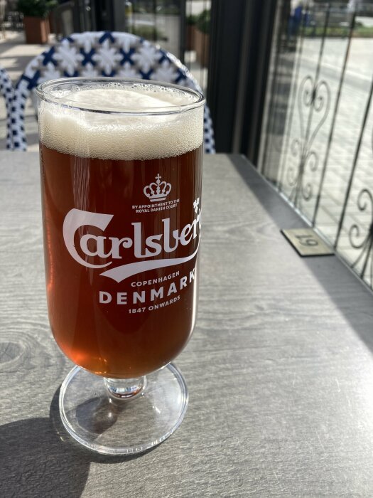 Ett glas Eriksbergs öl i solen på ett uteserveringsbord.