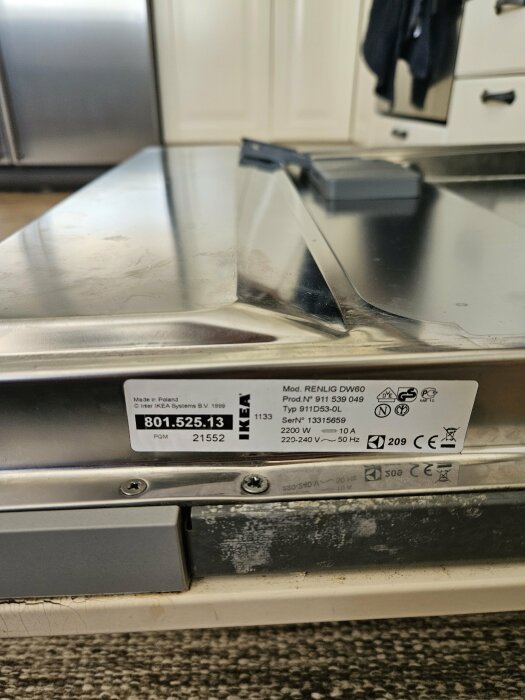 Bild på en IKEA Renlig diskmaskin med etikett och en saknad skruv vid frontpanelen.