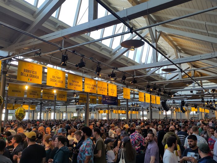 Folksam ölfestival inne i en stor hall med många besökare och bryggerier som visar upp sina öl.