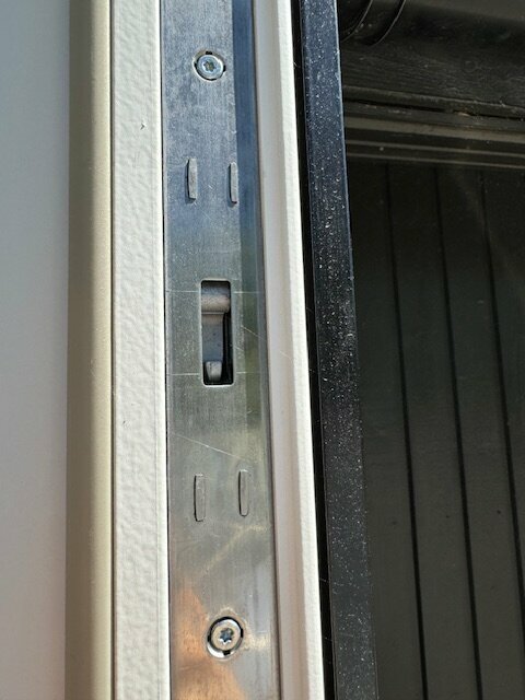 Metallregel på kant av dörr med utskärning för förreglingskolven, obehövlig extrafunktion ej använd.