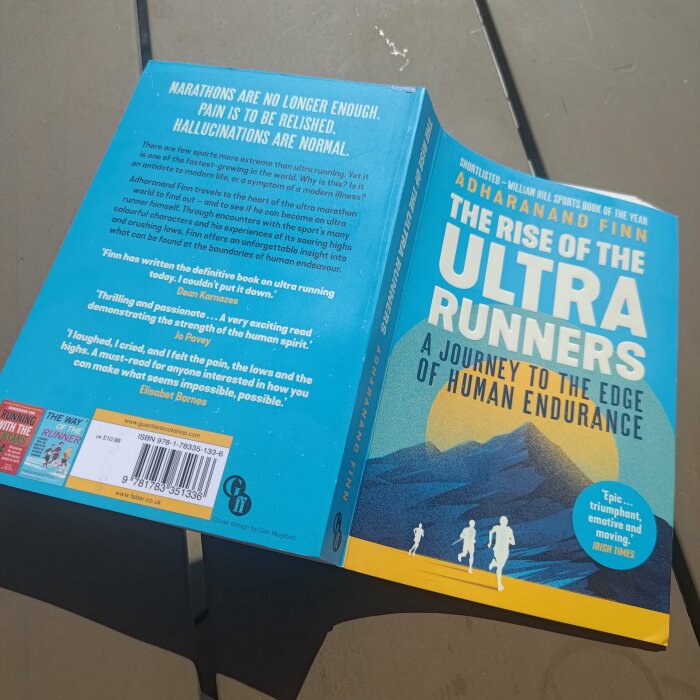 Boken "The Rise of the Ultra Runners" av Adharanand Finn öppen på en bordsskiva.