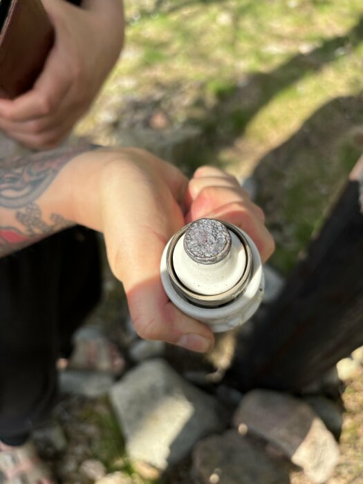 Närbild på en hand som håller en bränd mätarsäkring, tecken på elektriska problem.