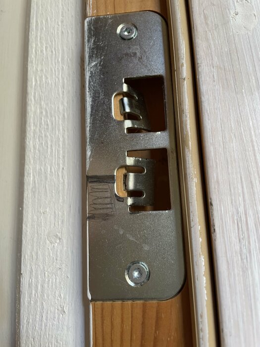 Felmonterad dörrdel som behöver justeras, med synlig skruv och spår.