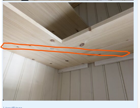 Hörnet av ett träskafferi med hyllplan stödda av plattjärn inmarkerade i orange.