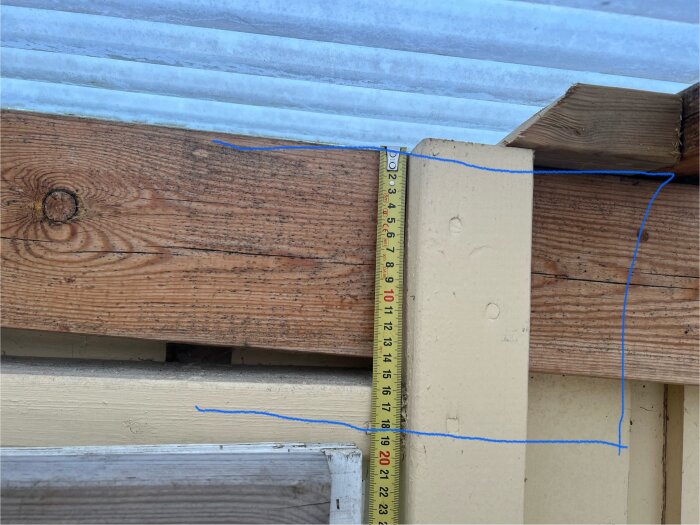 Måttband mot en befintlig 145 träregel markerad med blå linjer för att visa tilltänkt dimensionering för renovering.
