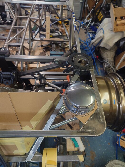 Tanklock monterat på en metallkonstruktion i en verkstad som är belamrad med verktyg och byggmaterial.