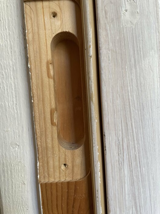 Närbild på en ofärdig dörrkarm med synlig urtagning för dörrlåset.