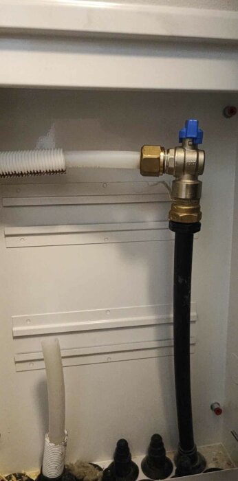 Värmesystem med rör och kopplingar i ett fördelarskåp, inklusive felaktigt 20mm golvvärmeslang.